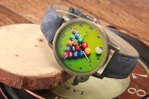 Detail of vintage bronze billiard watch with denim strap on rustic wood base