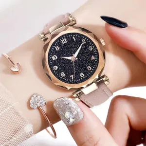 Detail of starry dial quartz watch with pink suede strap and rose gold heart bracelet