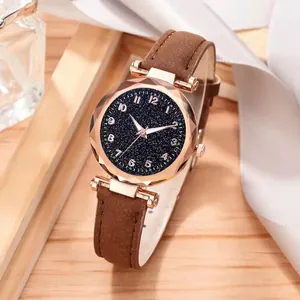Detailed close-up of ladies starry dial watch with brown suede strap and gold case