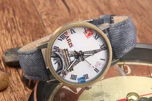 Dettaglio orologio vintage in bronzo con quadrante Tour Eiffel e cinturino in denim