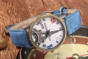Dettaglio dell'orologio retrò in bronzo con quadrante Torre Eiffel e cinturino in denim