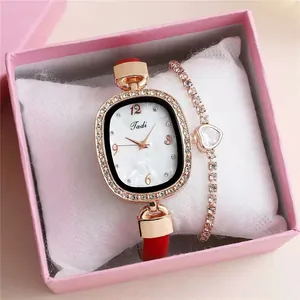Close-up of red leather quartz watch and gold heart bracelet in a gift box
