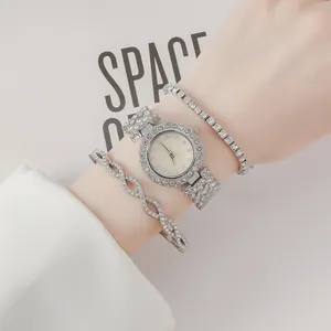 Vue détaillée de la montre argentée sertie de diamants avec bracelets assortis au poignet
