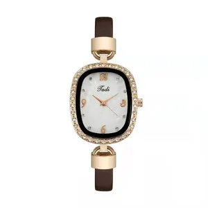 Detailed macro view of rose gold oval watch case with sparkling crystal bezel and Tadi logo