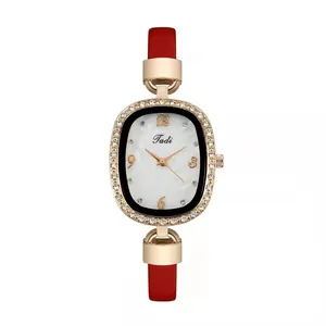 Elegant gold oval watch with rhinestone bezel and red leather strap on white background