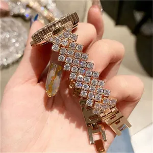 Detail van roségouden horloge met sprankelende strassteentjes en metalen H-schakelband