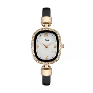 Detail of rose gold rhinestone bezel watch with marble dial and black leather strap