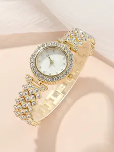 Détail de la montre à quartz dorée de luxe avec strass sur fond rose doux