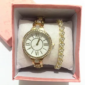 Dettaglio di orologio al quarzo dorato e bracciale con strass a cuore in scatola rosa
