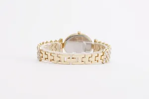 Detail of gold metal watch band featuring H-shaped links with micro-pave crystal setting