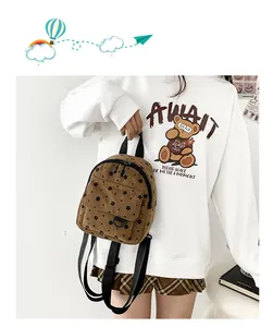 Detailed view of a brown corduroy mini backpack featuring cute black floral patterns