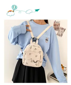 Mini corduroy backpack in off-white featuring black smile patterns and a front pocket