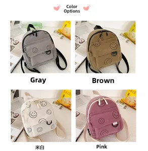 Detail of corduroy mini backpack featuring smiley face print in four casual colors