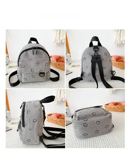 Detail view of mini grey corduroy backpack with smiley patterns and adjustable straps