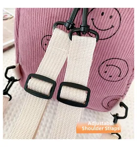 Detailed close-up of adjustable beige shoulder straps on a pink corduroy backpack