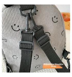 Detailed macro view of the adjustable black nylon shoulder strap on the corduroy bag