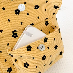 Detail eines Cord-Rucksacks mit Blumenmuster, Magnetschnalle und Innentasche gezeigt