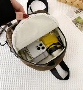 Internal capacity of corduroy mini backpack showing smartphone, umbrella and notebook