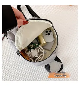 Internal capacity of gray corduroy backpack showing storage of phone and daily essentials