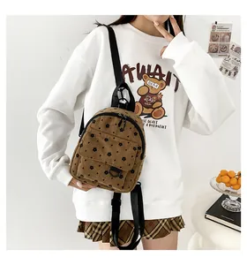 Detail of corduroy mini backpack with floral print, adjustable straps and dual zippers