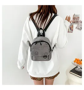 Detail of gray corduroy backpack with smiley face print and adjustable straps
