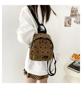 Brown corduroy mini backpack with floral print shown from a rear side view on model
