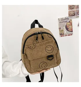 Detail of khaki corduroy backpack featuring smiley print and smooth double zipper closure