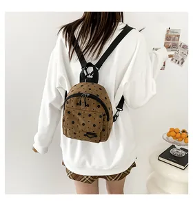 Detailed back view of a brown corduroy mini backpack with small black floral patterns