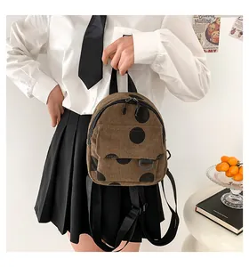 Mini corduroy polka dot backpack shown by model for size reference and daily styling