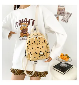 Detail of yellow corduroy mini backpack with black floral pattern and fabric straps