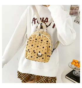 Detail of yellow corduroy backpack with flower patterns shown on a model's back