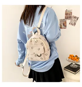 Corduroy mini backpack with smiley face prints shown on a model for size and fit