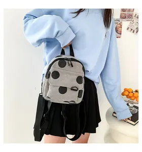 Detail of gray corduroy mini backpack with black polka dots and adjustable straps