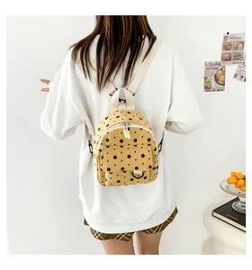 Detail view of mini corduroy backpack in yellow with floral pattern on model's back