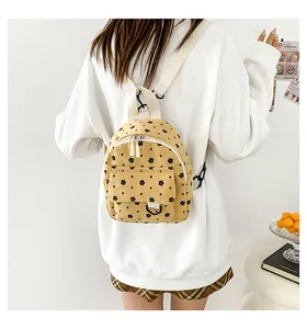 Close-up of ginger corduroy backpack featuring floral print and white adjustable straps