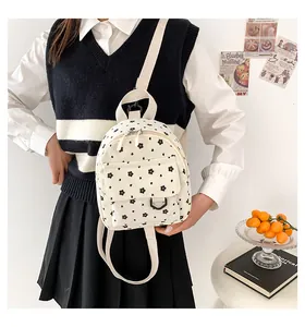 Detailed close-up of a mini floral corduroy backpack with black floral pattern