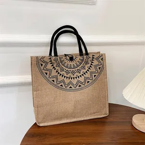 Detail van de jute tas met mandala print en zwart touw handvat in huiselijke sfeer