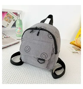 Detail of grey corduroy backpack with smiley prints showing texture and lifestyle use