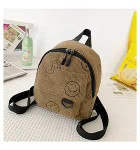 Macro detail of brown corduroy backpack with black smile print and zipper closure