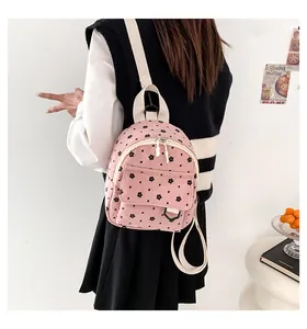 Detail view of the pink corduroy mini backpack with floral pattern on model