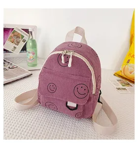 Macro shot of purple corduroy backpack texture with black smiley patterns and straps
