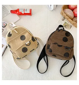 Close-up of vintage corduroy mini backpacks with polka dots and soft texture detail