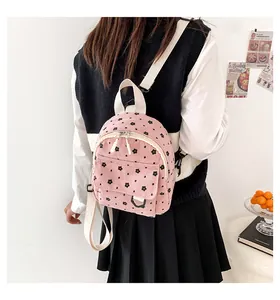 Detail of pink corduroy mini backpack with floral print on a female model back