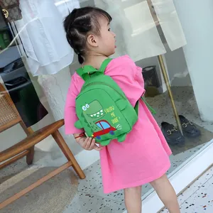 Grüner Dinosaurier-Kinderrucksack mit verstellbaren Gurten an kleinem Mädchen