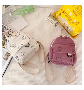 Close-up of smiley face corduroy backpack texture with D-ring buckle and adjustable strap