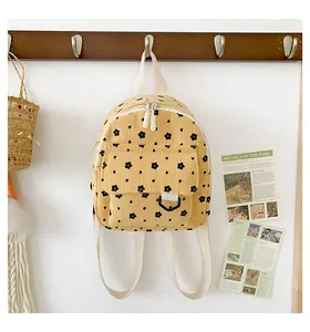 Detail of floral corduroy backpack featuring a black D-ring and dual zipper main pocket