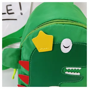 Gros plan du sac dinosaure pour enfants montrant la texture en nylon et les appliques