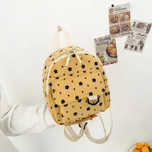 Yellow corduroy mini backpack with floral pattern and adjustable fabric straps