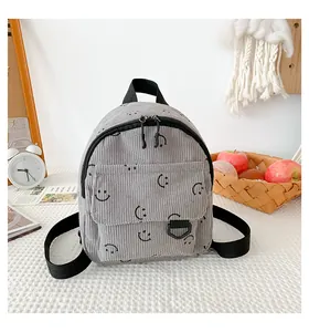 Close-up of dark grey corduroy backpack with smiley face pattern and textured fabric