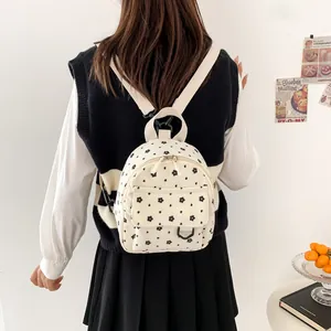Cute corduroy mini backpack for women featuring black flower patterns on cream white fabric